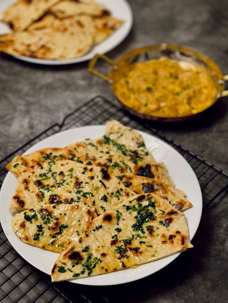 Garlic naan in a plate, with butter paneer in background. Easy Garlic Naan, Naan Without Yeast, Asian Bread Recipe, Garlic Naan Recipe, Asian Bread, Chicken Recipe Indian, Butter Paneer, Butter Chicken Recipe Indian, Vegetarian Asian