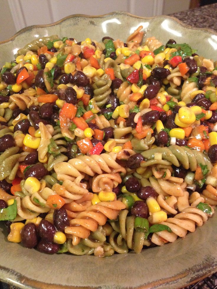 a bowl filled with pasta and vegetables on top of a table