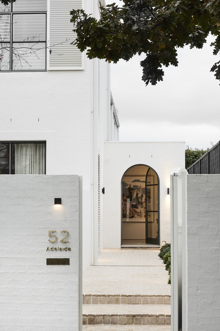 the entrance to an apartment building with white walls and steps leading up to it's front door