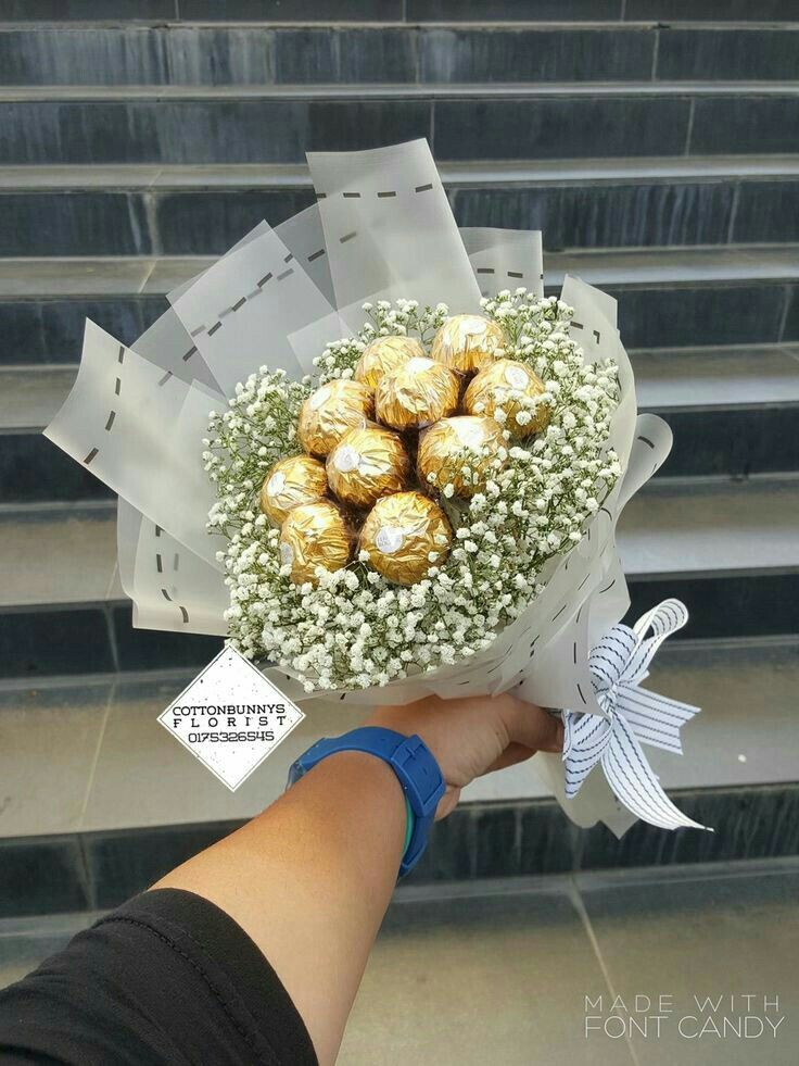 a person holding a bouquet of chocolates in their hand