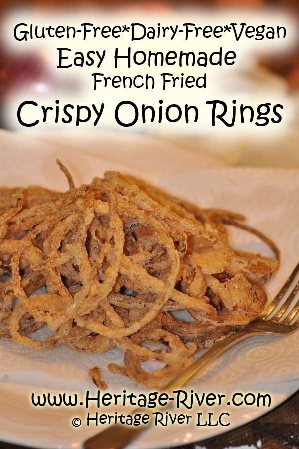 a white plate topped with onion rings on top of a table next to a fork