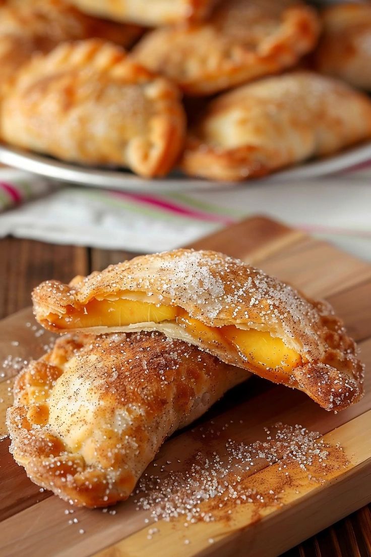 two pastries on a cutting board with powdered sugar