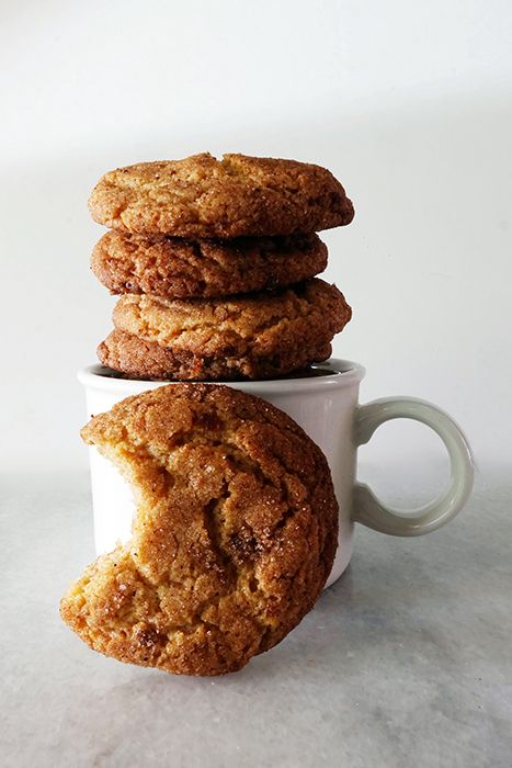 three cookies stacked on top of each other in a white coffee cup next to another cookie