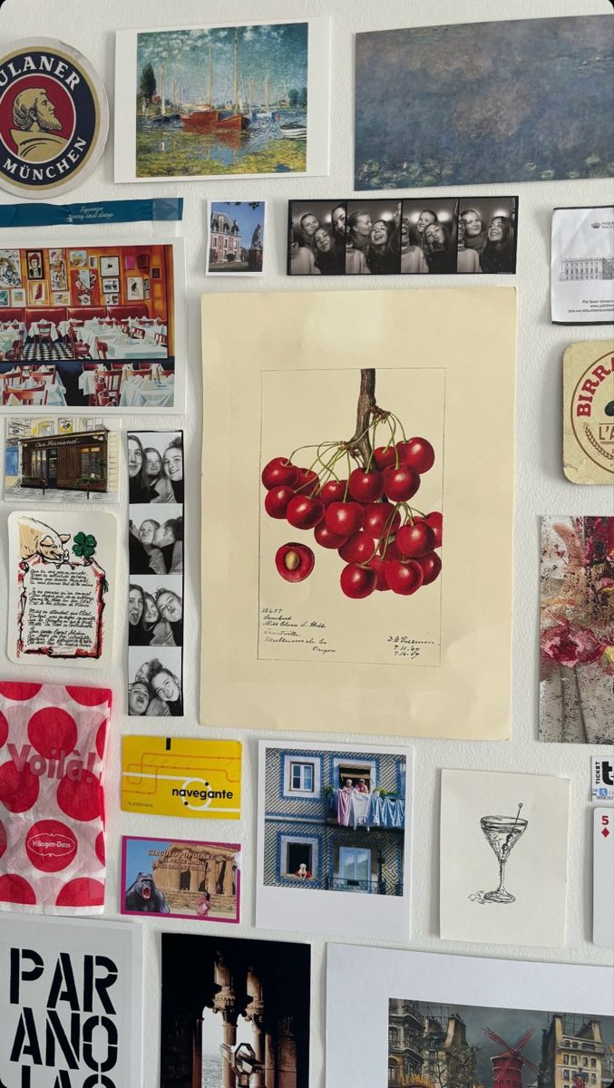 a refrigerator covered in pictures and magnets with red cherries on the fridge door