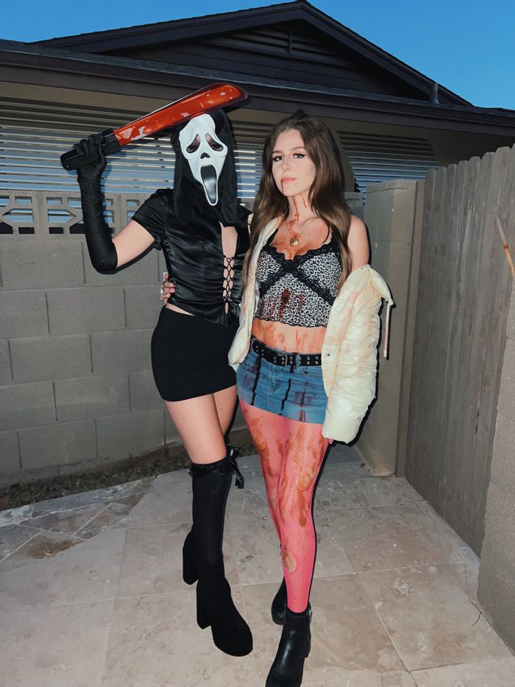 two women dressed up in costumes and holding skateboards