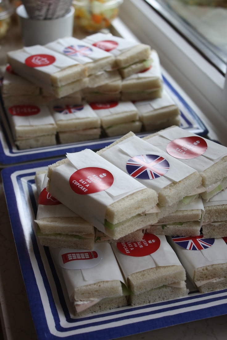 sandwiches are stacked up on plates in front of a window with the british flag painted on them