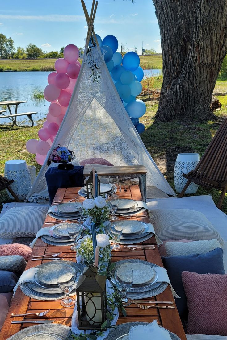 a table set with plates and place settings in front of a teepee tent