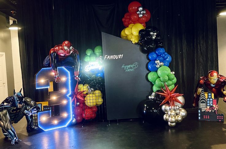 balloons are arranged in the shape of letters and figures on a stage with black curtains