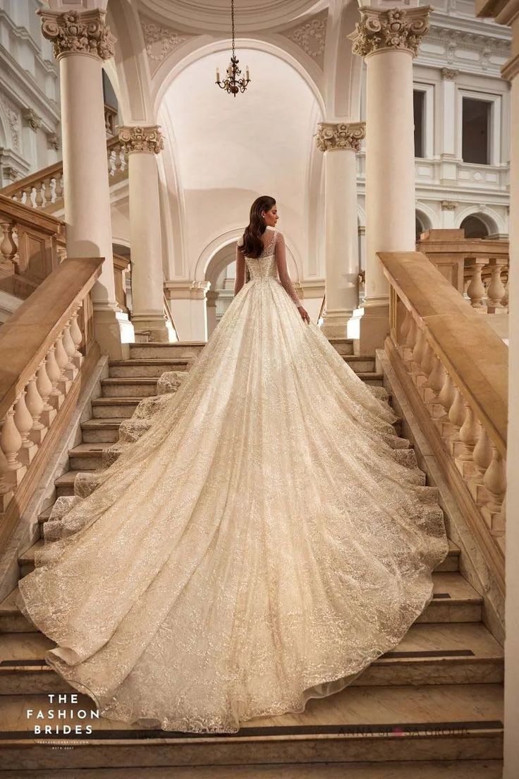 a woman in a wedding dress standing on some stairs