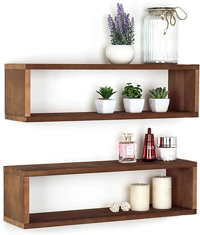 two wooden shelves with plants and candles on them