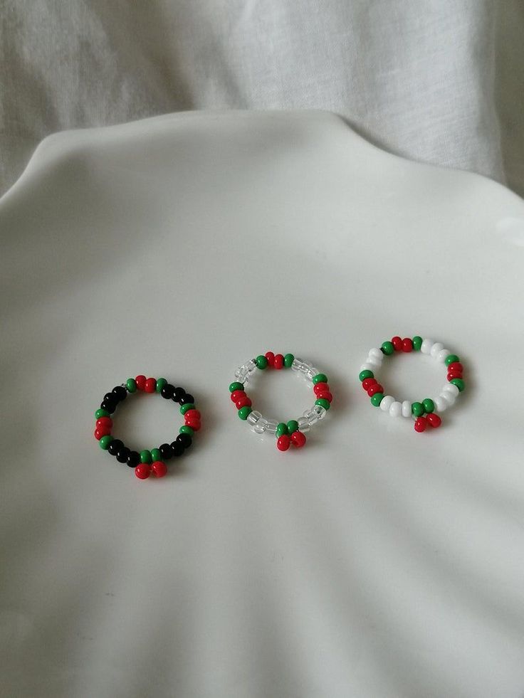 three beaded bracelets sitting on top of a white table next to each other