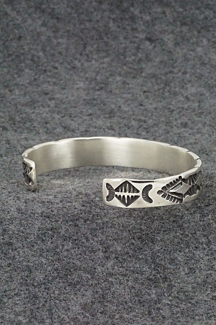 This sterling silver bracelet was made by Navajo silversmith Elvira Bill. The inside is signed Elvira Bill and stamped sterling.Size: 5 7/8" (will fit up to a 7 3/8" wrist)Gap: 1 1/2"Width: 3/8"Free shipping on all orders! We ship with USPS and always include tracking. All orders ship within a day of payment.Returns are accepted up to 30 days after you receive your order. Just send us a message. Our shop offers cash back or store credit. The item must be returned in new condition. Adjustable Sterling Silver Bracelet In Antique Silver, Adjustable Artisan Sterling Silver Bracelet, Antique Silver Sterling Silver Bangle Bracelet, Silver Etched Sterling Silver Cuff Bracelet, Southwestern Sterling Silver Bracelet Stamped 925 As Gift, Bohemian Sterling Silver Bracelet With Oxidized Finish, Artisan Adjustable Bracelets Stamped 925, Artisan Sterling Silver Bangle Bracelet, Sterling Silver Stamped Bracelet