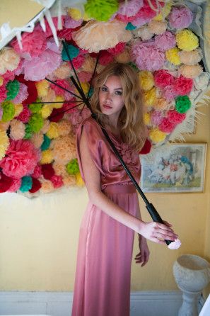 a woman in a pink dress holding an umbrella over her head with flowers on it