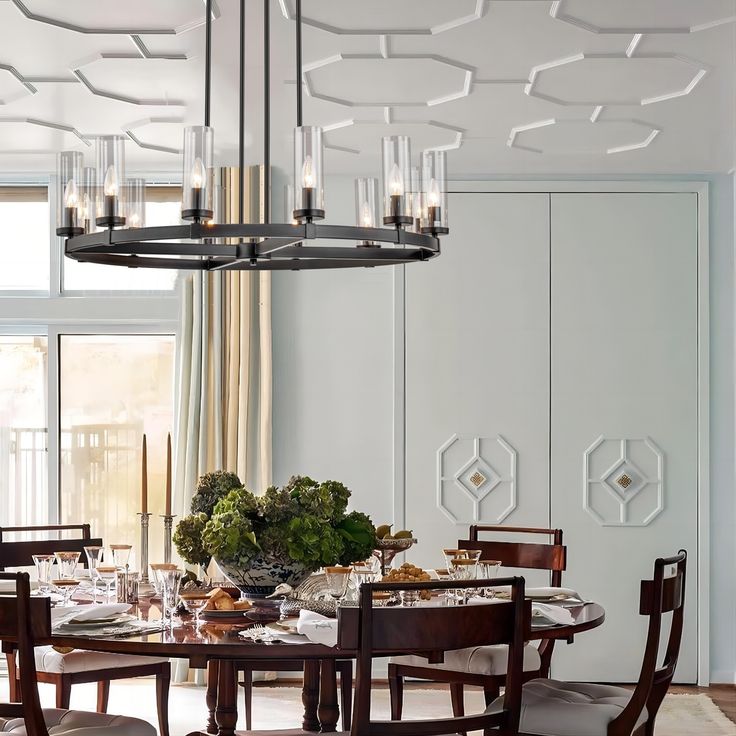 a dining room table with chairs and a chandelier hanging from the ceiling above it