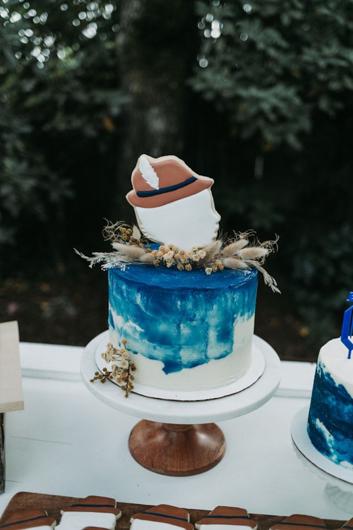 there is a blue and white cake on top of a table with other items around it