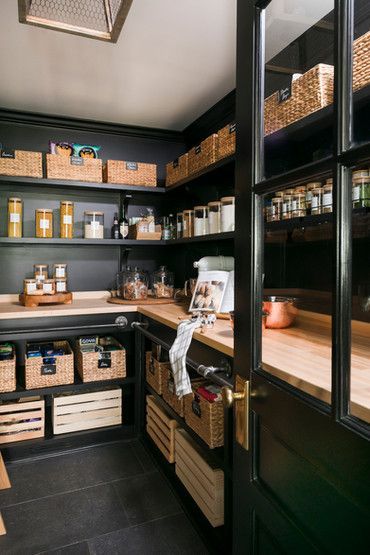 an organized pantry with lots of items in baskets and boxes on the counter top, along with wooden shelves