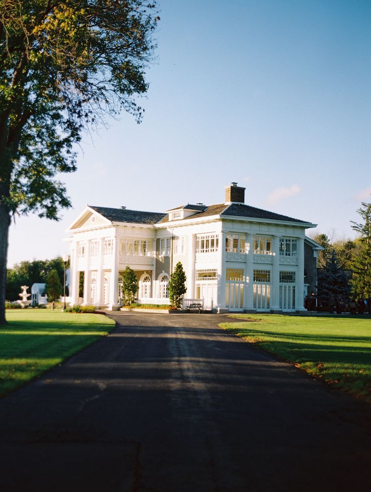 a large white house sitting on the side of a road