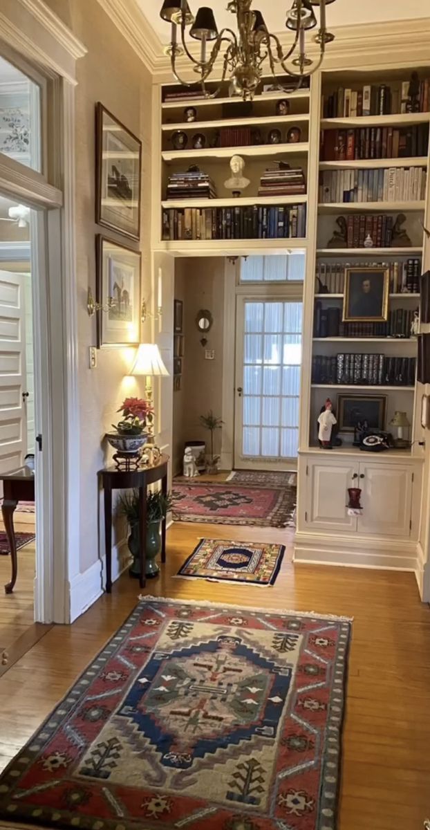 a living room filled with furniture and a chandelier above a rug on the floor