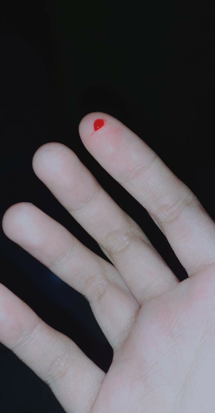 a person's hand with red nail polish on it