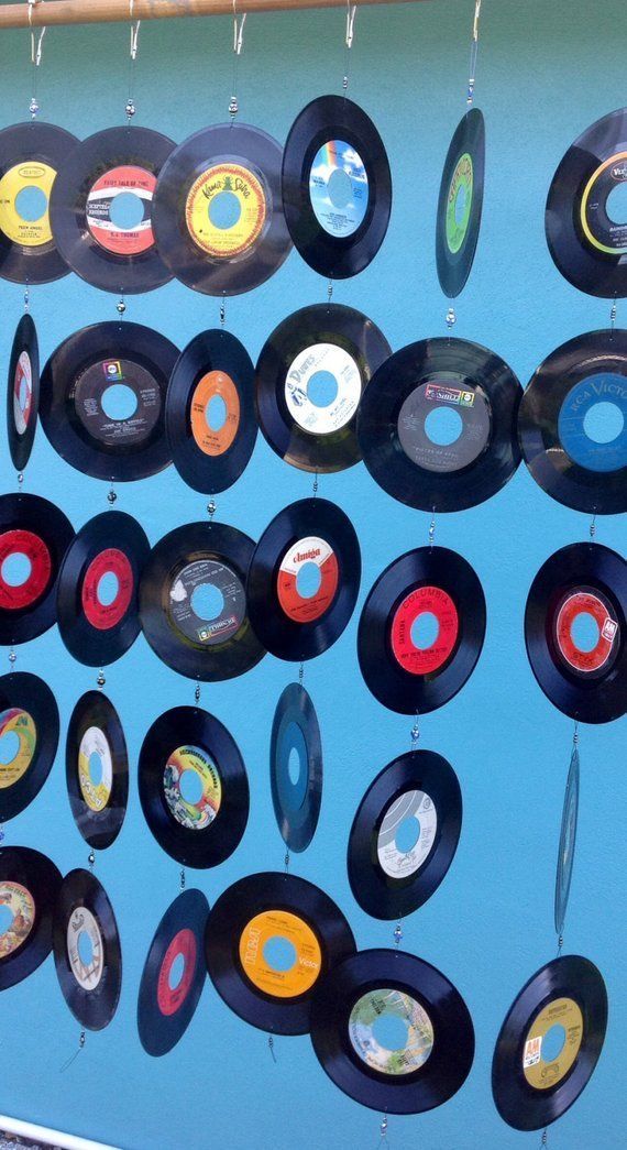 an array of old records hanging on a blue wall with circles and dots in them