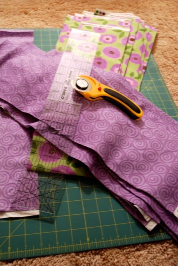 a pair of scissors sitting on top of purple fabric next to a piece of cloth