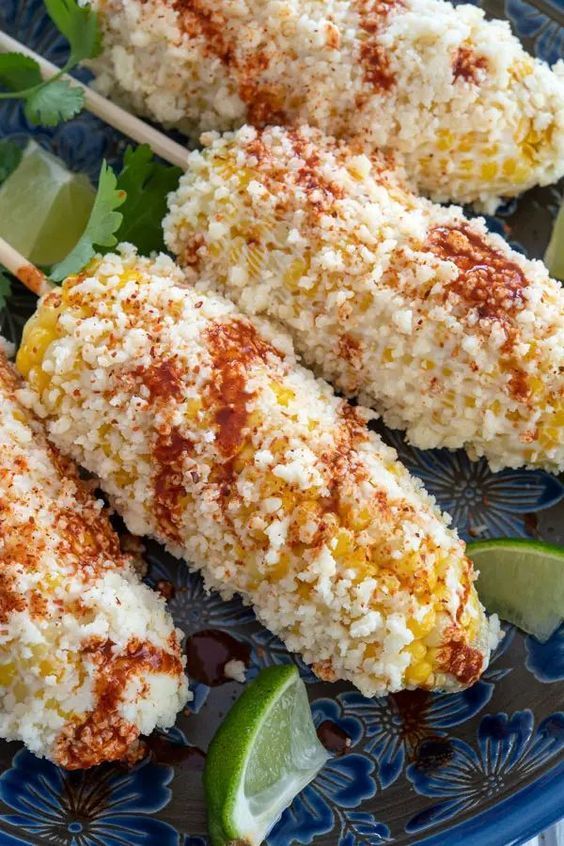 chicken skewers covered in rice and garnished with limes on a blue plate