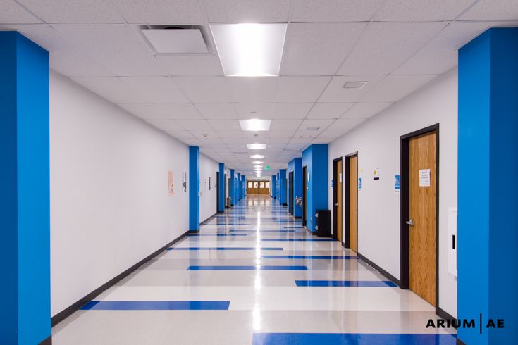 an empty hallway with blue doors and white walls