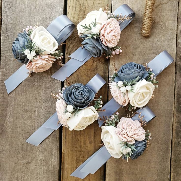 three bouquets of flowers are sitting on a wooden table