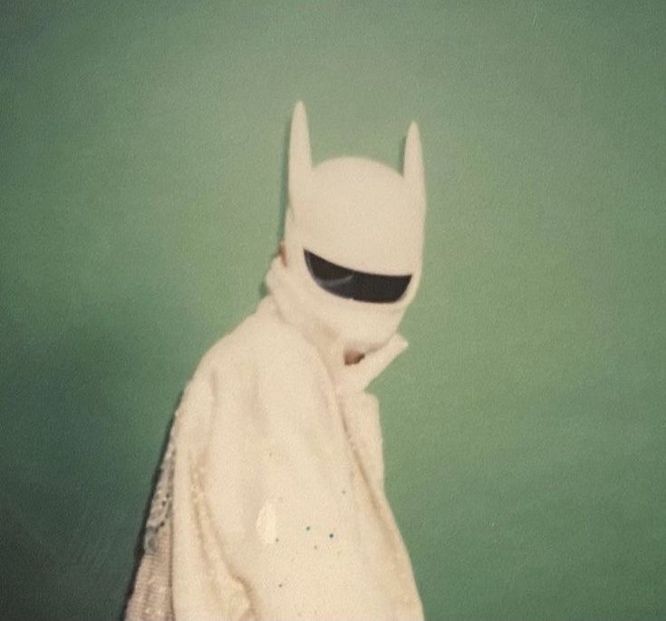 a person in a white batman costume and sunglasses