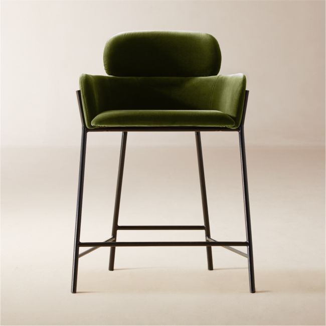 a green chair sitting on top of a white floor next to a black metal frame