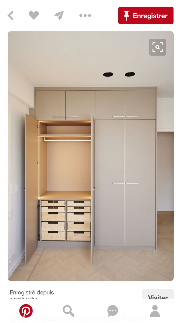 an empty room with white cabinets and drawers on the wall, next to a closet