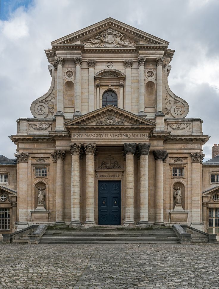 an old building with columns and a blue door