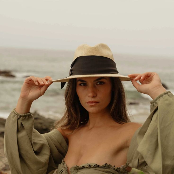 Natural straw fedora with broad brim and oversized black grosgrain band, wrapped asymmetrically around the hat and finished with a modern angular fold. 9cm brim length 9.5 cm crown height Hand Woven Panama Hat from Paja Toquilla straw Each hat is unique and reflects the natural beauty & variation of the handicraft process Small/Medium (55 cm - 57 cm), Large (58 - 59 cm) Elegant Wide Brim Toquilla Straw Fedora, Elegant Fedora Panama Hat For Vacation, Chic Short Brim Panama Hat In Toquilla Straw, Chic Wide Brim Panama Hat In Toquilla Straw, Elegant Fedora With Curved Brim For Vacation, Chic Toquilla Straw Panama Hat With Wide Brim, Chic Toquilla Straw Panama Hat With Short Brim, Chic Panama Hat With Short Brim In Toquilla Straw, Beach Boater Hat With Structured Crown