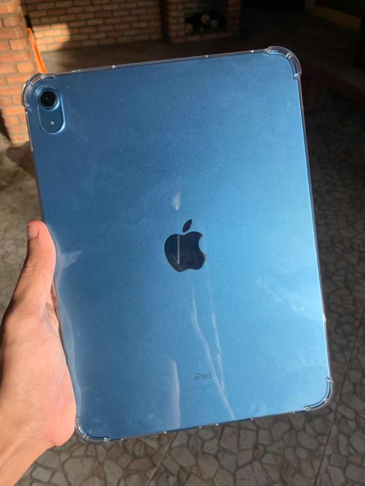 a person holding an apple ipad in their hand with the back cover partially removed from it