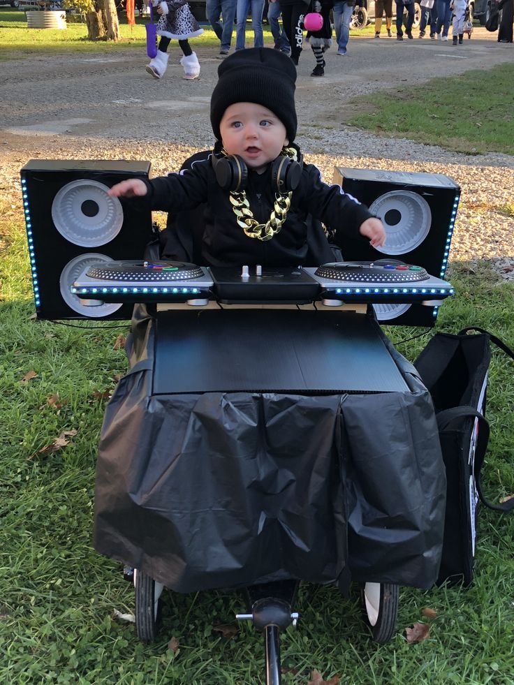 a small child in a black outfit is playing with a dj's set up