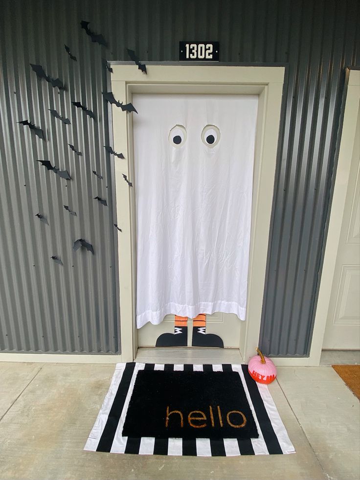 a halloween door with two eyes and a black and white rug in front of it