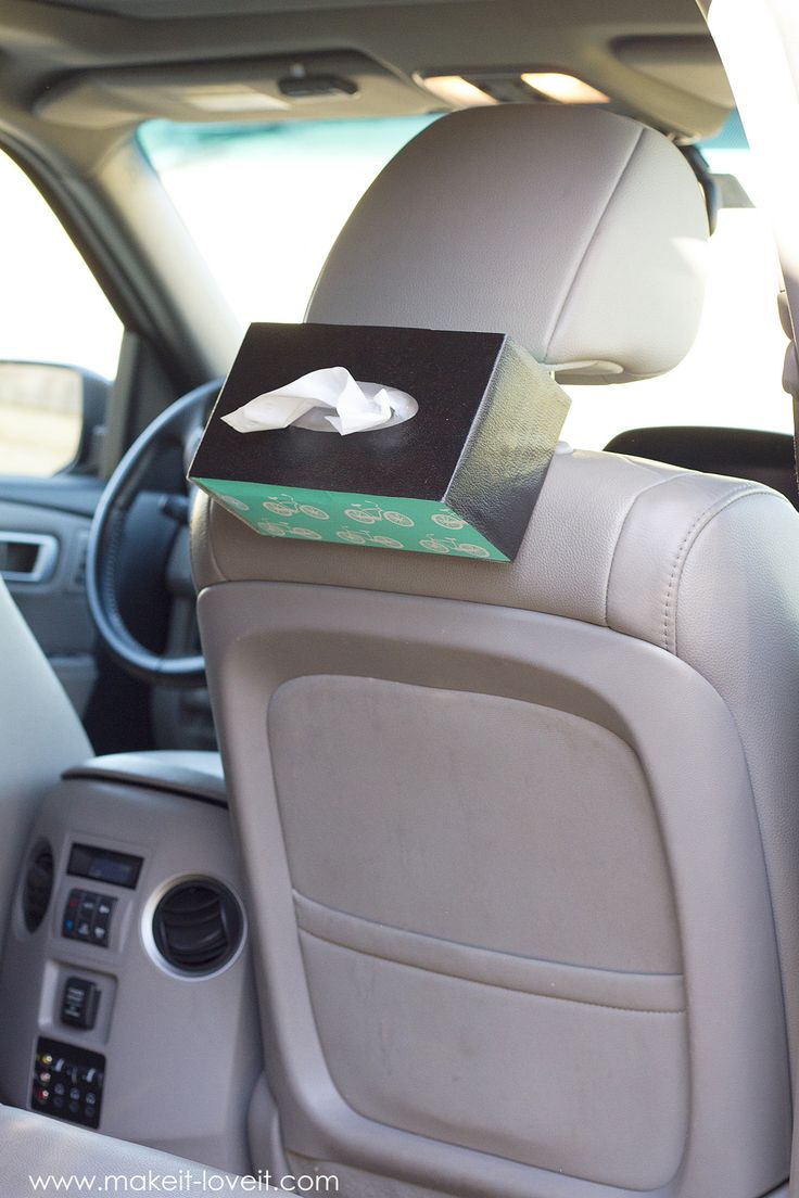 the interior of a car with a box in the back seat and an electronic device on top