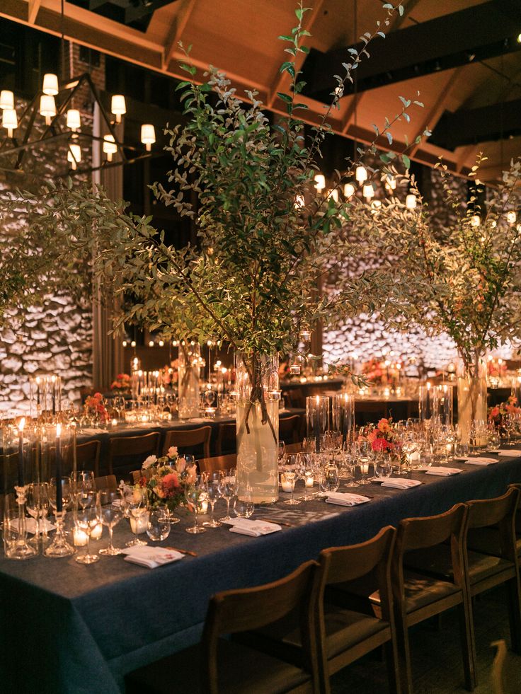 a long table is set up with candles and centerpieces for an elegant dinner