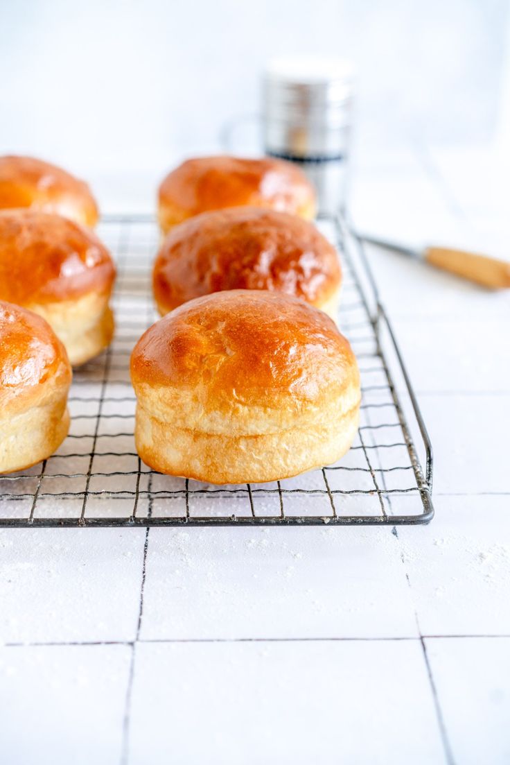 several glazed donuts cooling on a wire rack