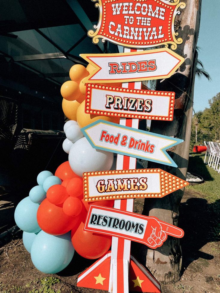 a street sign with many different signs on it's sides and balloons in the shape of flags