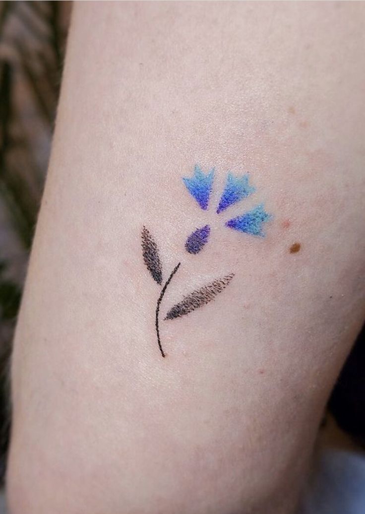 a blue flower tattoo on the leg