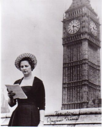 a woman standing in front of a tall clock tower with a poem written below her