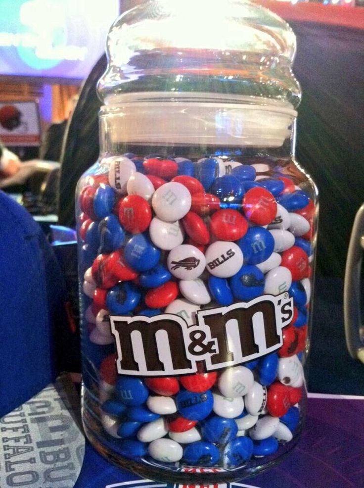 a glass jar filled with m & m's candies on top of a table