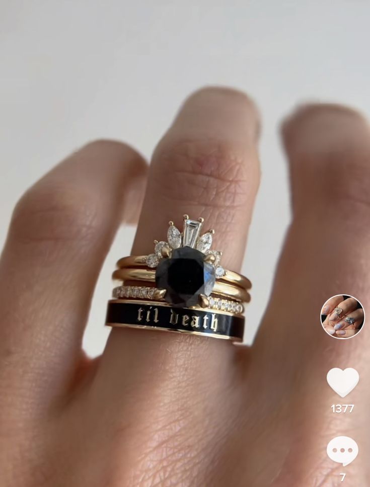 a woman's hand with two different rings on it and one has a black diamond