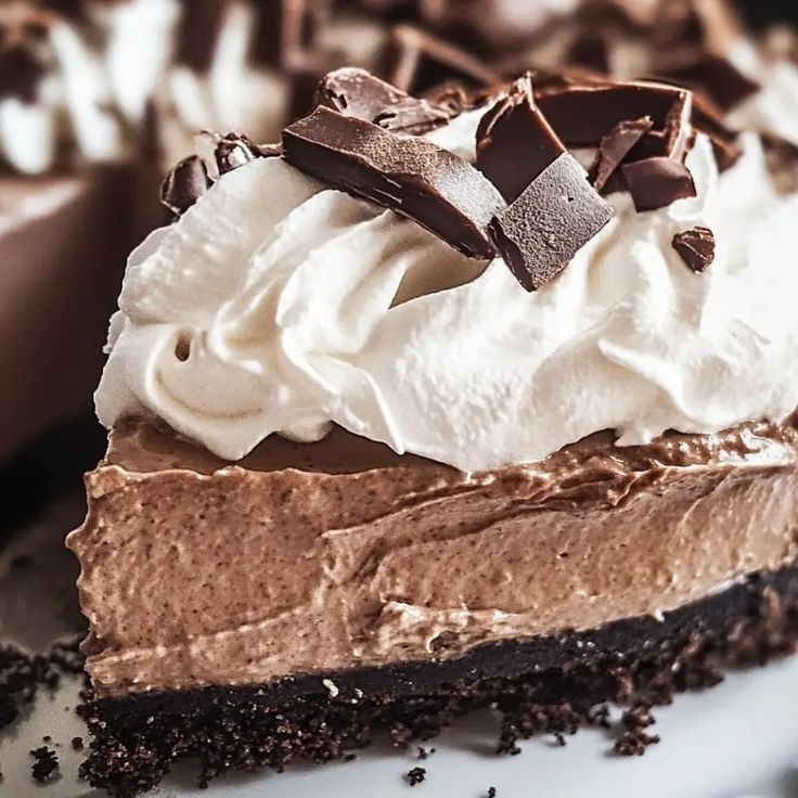 a piece of chocolate pie with whipped cream and chocolate shavings on the top