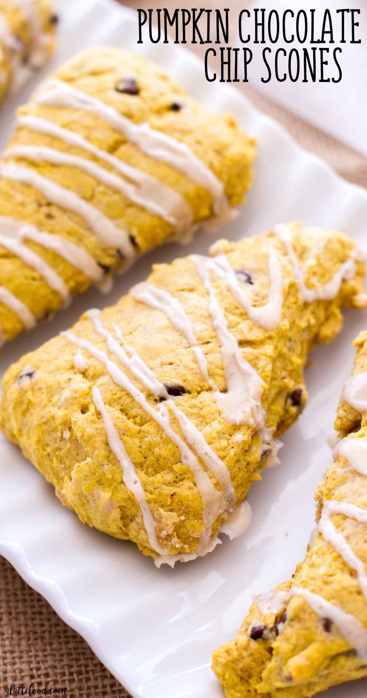 pumpkin chocolate chip scones with icing on a white plate next to other scones