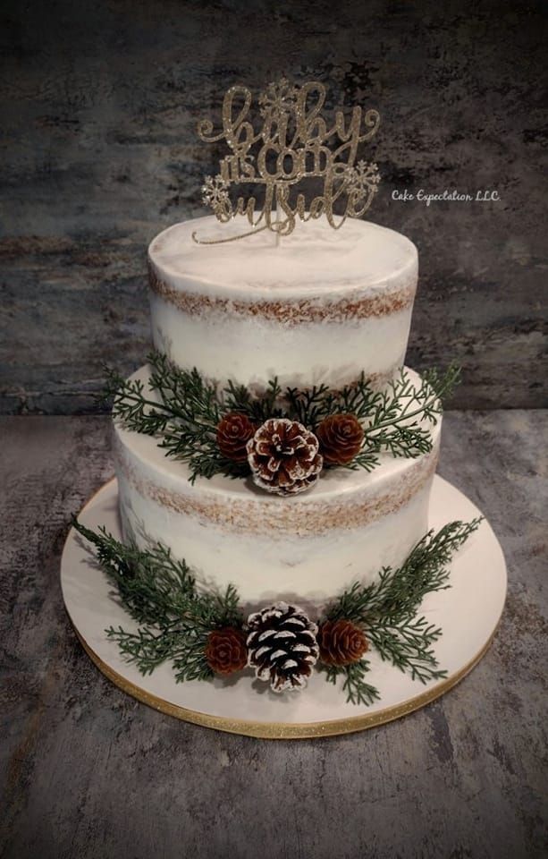 a three tiered cake with pine cones on top