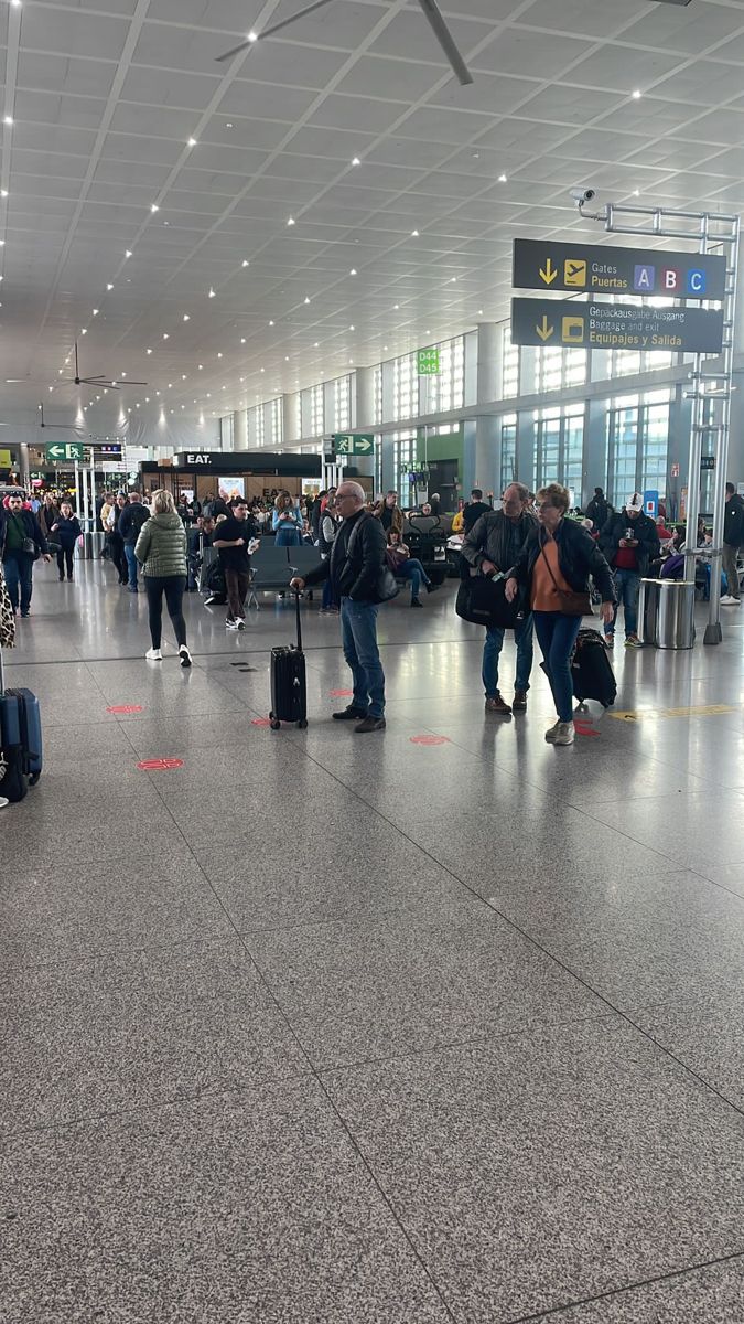 many people are walking through an airport with their suitcases and bags on the ground