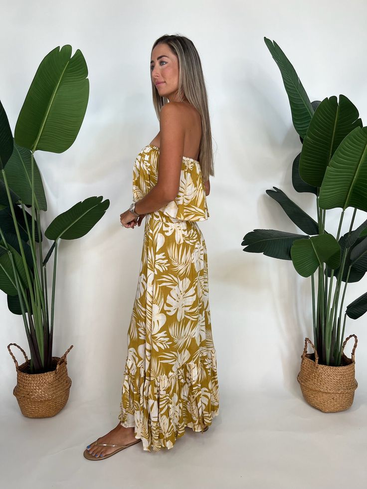 Effortlessly stunning, the Tiare Hawaii Bungalow Maxi Gold is a must-have for any summer wardrobe. Featuring an unlined design, a strapless bodice overlay, and a thick elastic waistband, this dress offers both style and comfort. Its floor length single tiered skirt adds an elegant touch, making it perfect for any occasion. 100% Rayon Unlined Thick Elastic Waistband For An Adjustable Fit Hand Wash Cold, Lay Flat To Dry Alyssa is 5'10" Chic Strapless Sundress For Beach, Strapless Bandeau Dress With Smocked Back For Day Out, Beach Season Strapless Sundress, Strapless Summer Sundress For Brunch, Summer Vacation Strapless Dress, Summer Strapless Sundress For Brunch, Strapless Summer Dress For Vacation, Chic Bandeau Strapless Dress For Beach Season, Summer Strapless Mini Dress For Vacation