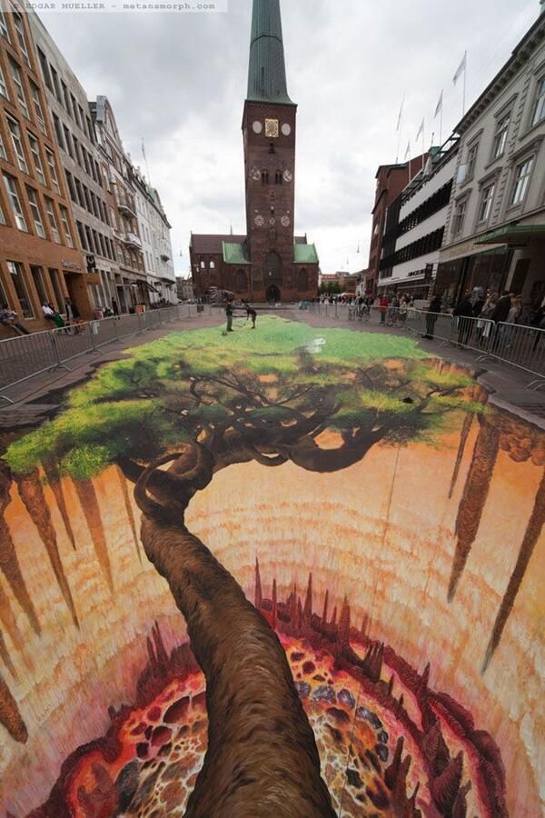 a tree is painted on the ground with buildings in the background